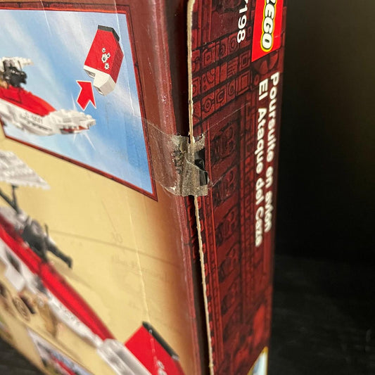 Clear Sellotape applied directly across the opening flap of a vintage LEGO box, showing how adhesive tape can mark and potentially damage collectible cardboard packaging.