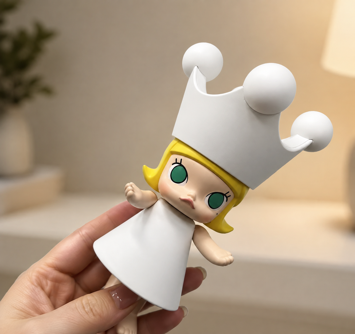 Hand holding the POP MART MEGA Royal MOLLY 150% paint-your-own figure, showing its large white crown and size for scale.