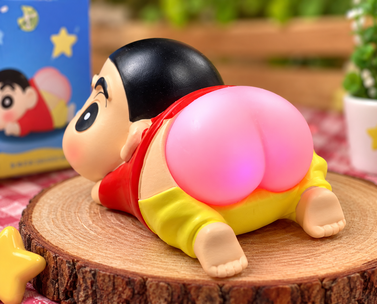 Crayon Shin-chan Light-Up Butt Lamp collectible figure featuring Shin-chan lying on his tummy with a cheeky raised bottom glowing softly pink.