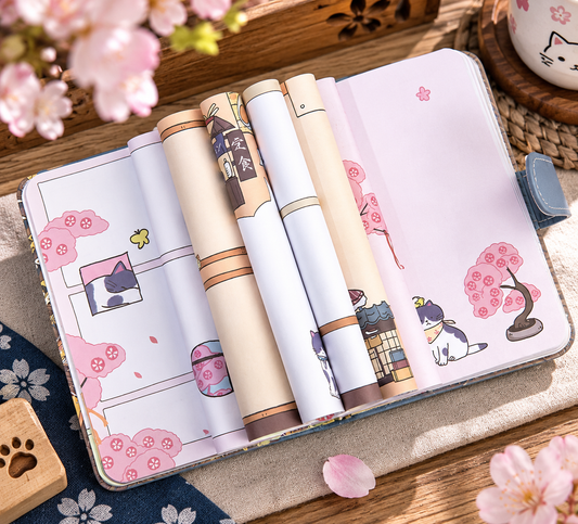 MUROO Sakura Cat notebook opened to colourful illustrated pages featuring cats, cherry blossom and Japanese scenery