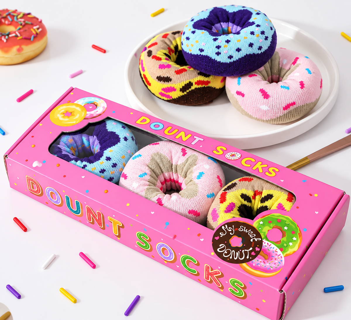 Pink doughnut-themed gift box containing three pairs of kawaii novelty socks designed to resemble colourful iced doughnuts with sprinkles.