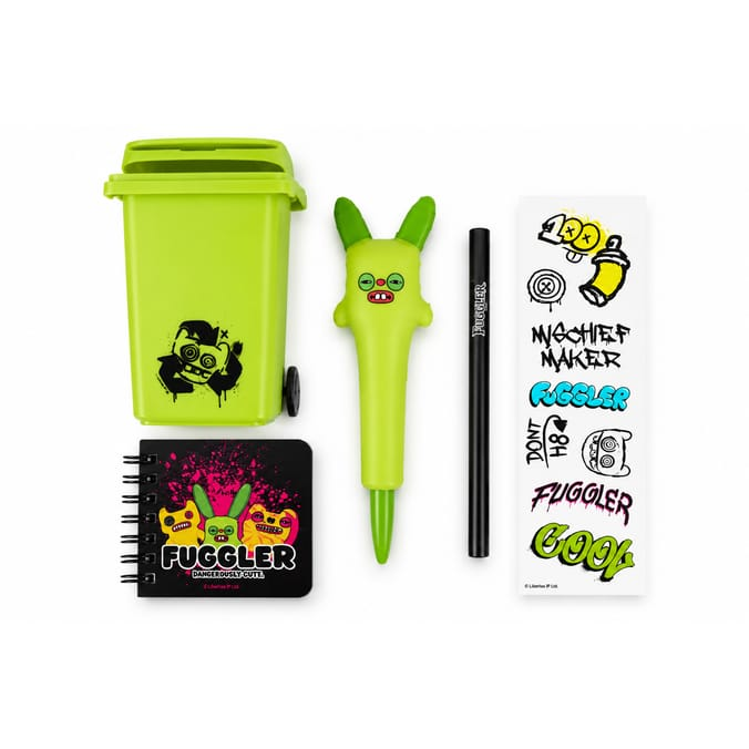 Fuggler stationery gift set contents arranged on a white background, including a lime-green wheelie bin stationery pot, green rabbit novelty pen, black Fuggler pencil, mini spiral notebook and colourful Fuggler sticker sheet.