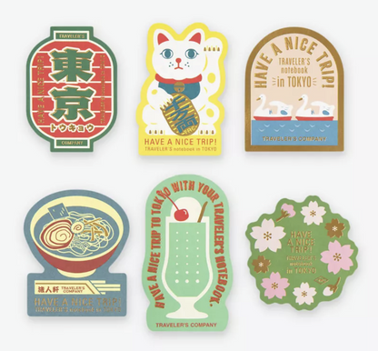 Six TRAVELER'S COMPANY Tokyo Edition stickers featuring Tokyo lettering, Maneki-neko lucky cat, swans, ramen, melon soda and cherry blossoms.