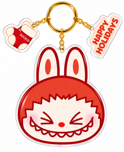 Pop Mart Christmas Labubu acrylic mirror keychain featuring red bunny ears, cheeky smiling face, gold keyring, Christmas stocking and Happy Holidays charms.