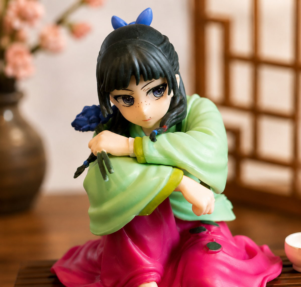 Close-up of Maomao Apothecary Diaries figure showing face, braided hair and blue flower