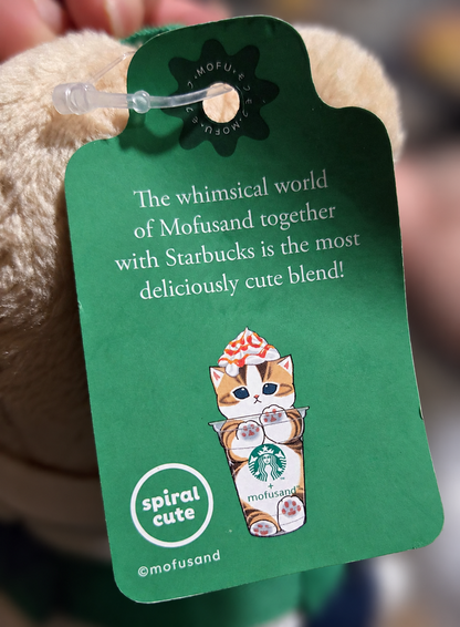 Reverse of the official Starbucks × Mofusand 2026 swing tag featuring an illustrated cat inside a Starbucks drink cup and Spiral Cute branding.