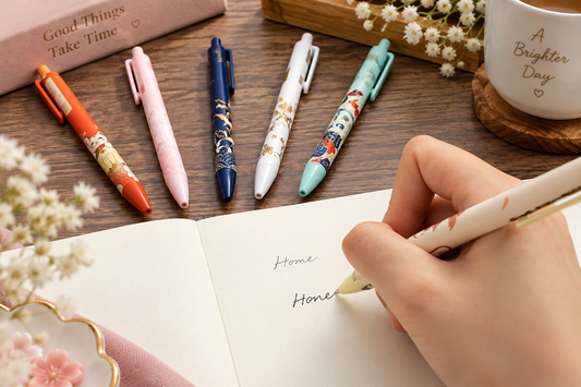 Decorative Chinese gel pen being used in a notebook with matching colourful pen set displayed behind