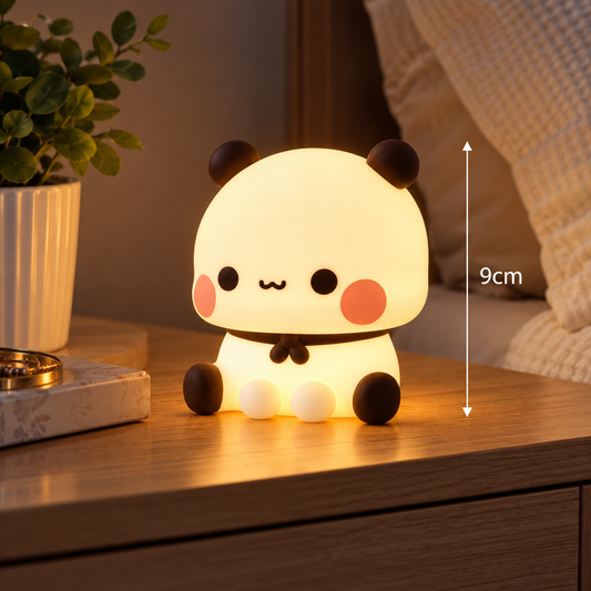 Small 9cm kawaii panda silicone LED night light glowing on a wooden bedside cabinet in a cosy bedroom.